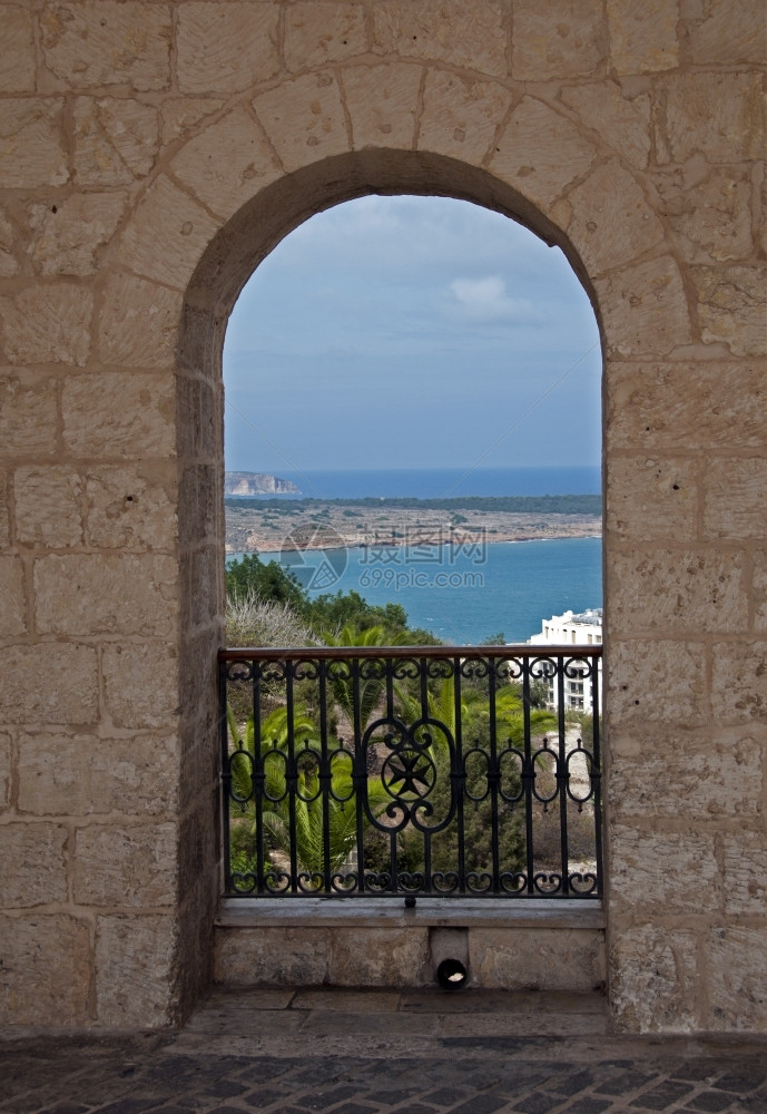 夏天海洋屋马耳他岛上石块弓下金属围栏的栅图片