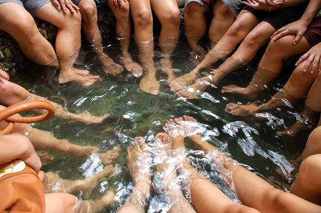 年轻的男人在自由户外的温泉中放松地浸泡着脚水人类图片