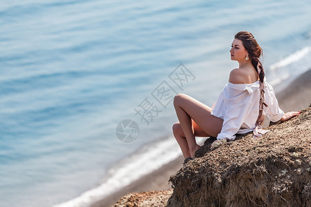水女孩坐在岩石上看着海女服装图片