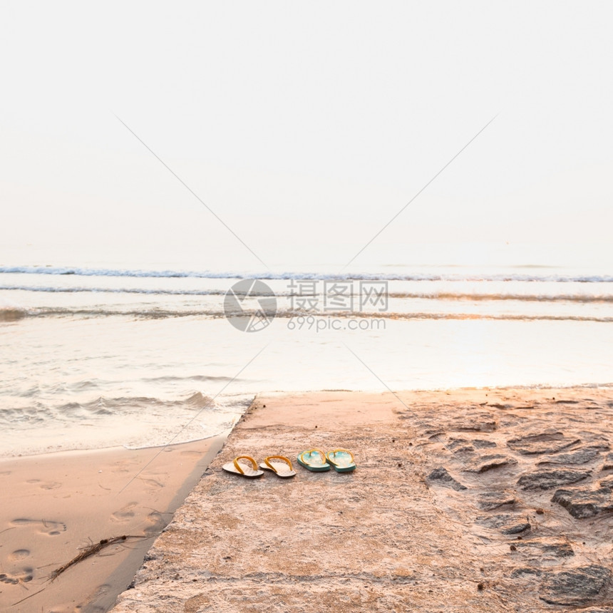 太阳光海洋在滩上的鞋子脱在海沙上行走图片
