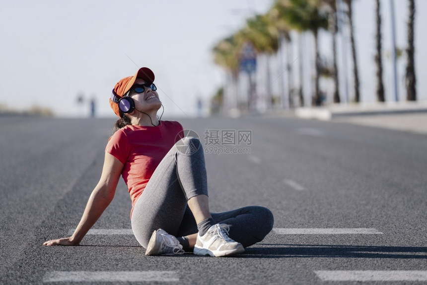 畅快女人在路上坐着然后带耳机跑风景一种图片