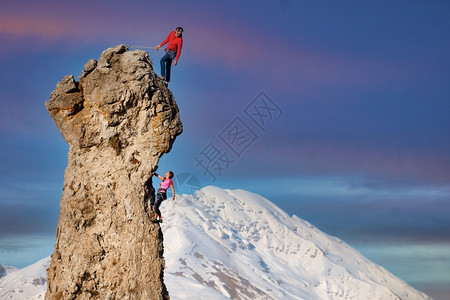 带领男和女摇滚攀岩者领先确保合作伙伴的安全男人团队合作图片