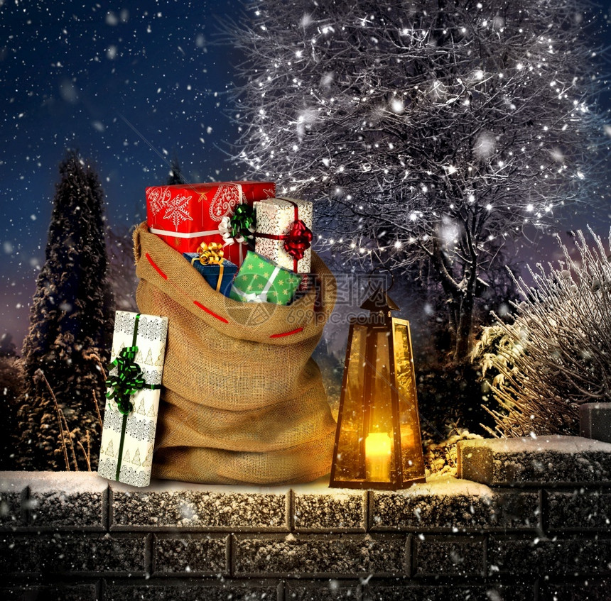 棕色的结石庆典圣诞老人赠送口袋在冬季户外花园放礼物箱用灯笼和蜡烛装上绿灯用圣诞树铺设姜饼小屋图片