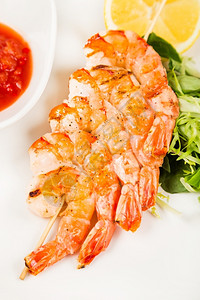 用红酱在菜槽上供应热虾的串烧服务图片
