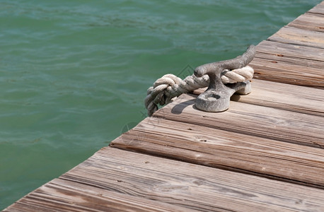 防沙固水木制码头绿色环礁湖上的旧铁系固克拉游艇木制的老背景