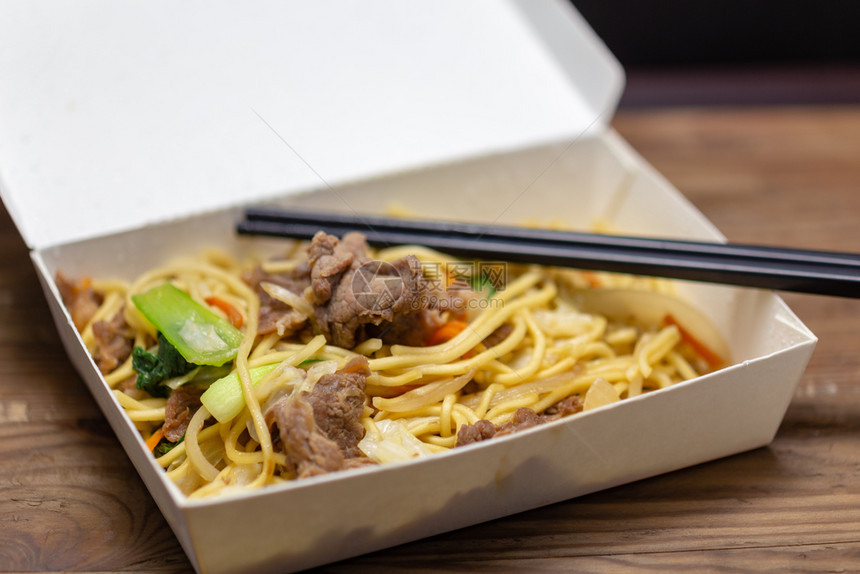 快速地猪肉炒饭配有筷子的午餐盒搅拌煸炒图片