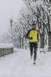 在雪天跑步的男性图片