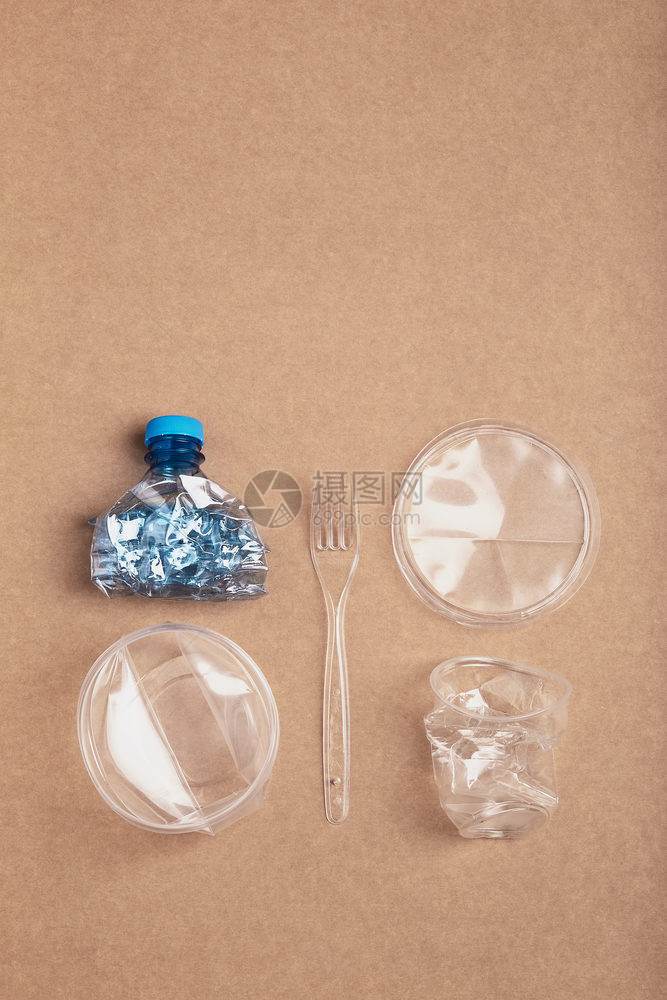 生态的浪费纸板背景上压扁的塑料瓶盒子杯和叉收集塑料垃圾以回收污染和过多垃圾的概念在顶部复制空间用过的图片