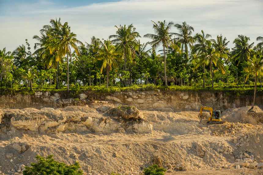 地点采掘棕榈树岩石和拖拉机采掘热带丛林中阳光明日天气的热带雨林采石场在热带森林中开采建石挖掘印度尼西亚图片
