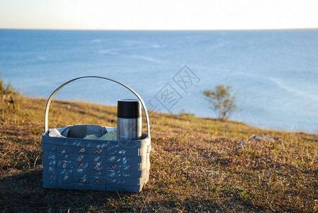 海岸边地面上带咖啡热水池的篮子草地平线夏天图片