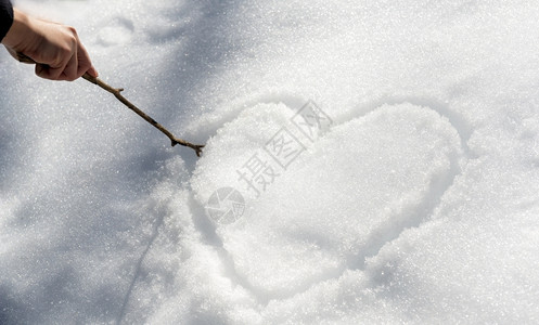心冷寒冷的霜一只手用棍子在雪中画出爱心冬天背景