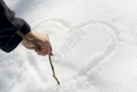 冷心清自然地面冷若冰霜一只手用棍子在雪中画出爱心背景