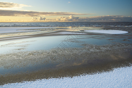 海上升明月冬季清晨在波罗的海雪沙滩上升起阳光中云彩的美丽反光照耀着日出思早晨设计图片