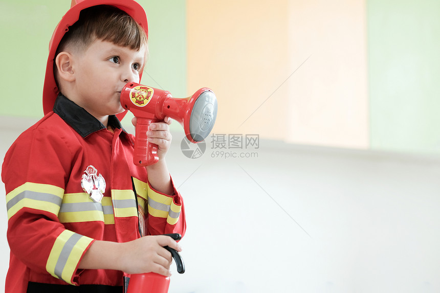 角色扮演消防员的男孩图片