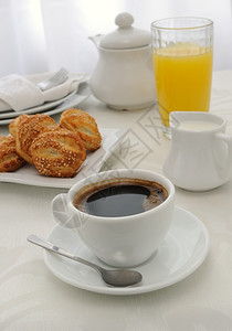 食物早晨清一杯咖啡加新鲜的烤面包卷含芝麻种子果汁和牛奶糕点图片