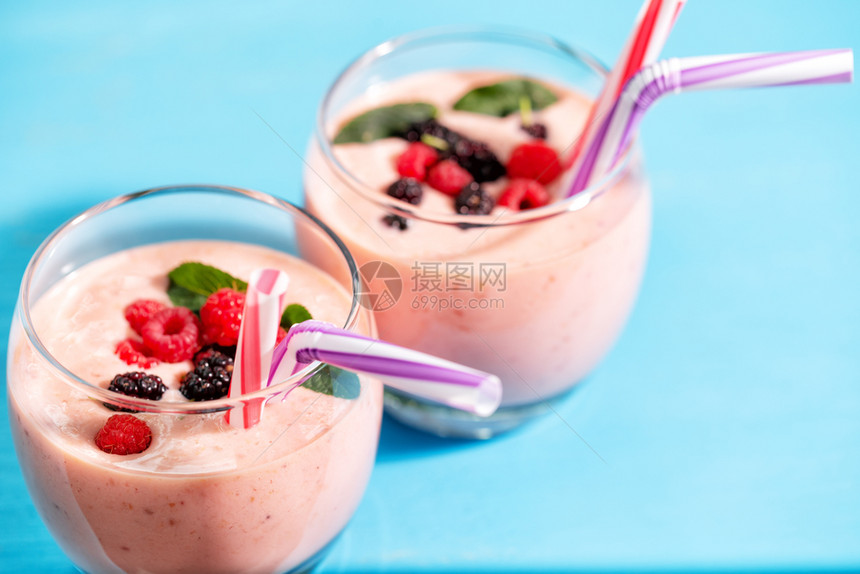 鸡尾酒覆盆子一种在夏天的蓝桌上带草莓和薄荷浆的果子玻璃带草莓和薄荷浆的红凉水玻璃图片