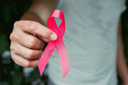 手拿粉色丝带预防癌症概念图片