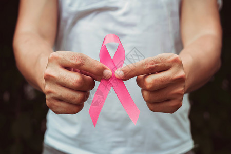 手拿粉色丝带预防癌症概念图片