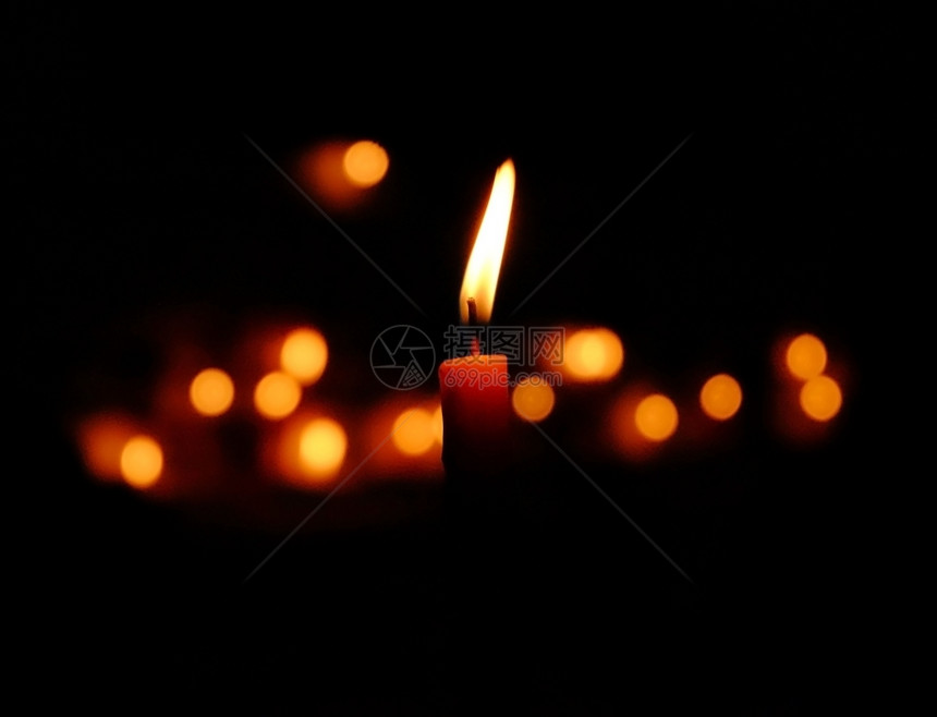 纪念火焰蜡烛光在黑暗中闪耀与布基背景黑色的图片