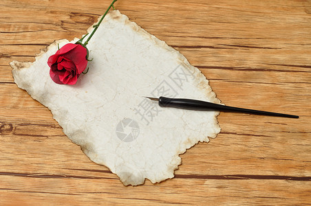 信息古老的黑钢笔旧纸和红玫瑰磨损床单图片