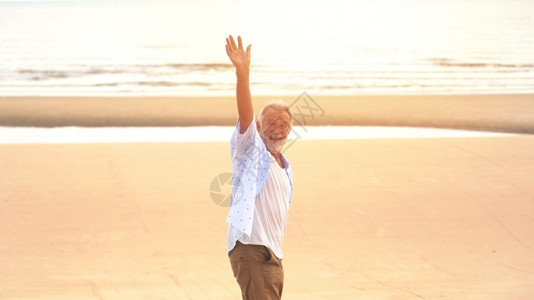 退休天空快乐老人手在沙滩上白种人图片