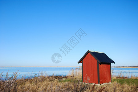 草水红木屋在海岸边背景是瑞典奥兰大桥布里奇背景图片