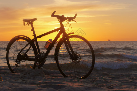 自然户外海沙滩上自行车的剪影日落时自行车日落时的自行车沙滩上的剪影图片