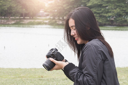 漂亮的快乐亚洲女看照片亚洲夏季旅游概念摄影师景观图片