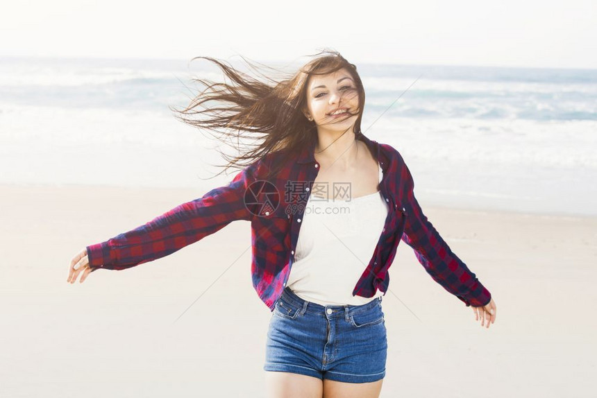 健康女士一个快乐孩在沙滩上跑步时的肖像夏天图片