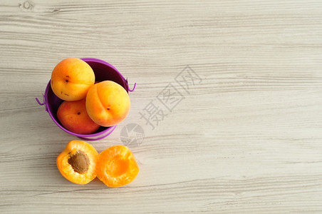 甜的健康一桶装满了杏子的旁边有两块丢了明亮的图片