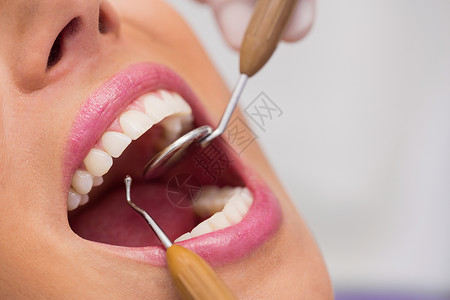 约定保持白种人近距离检查女病人牙齿的科医生图片
