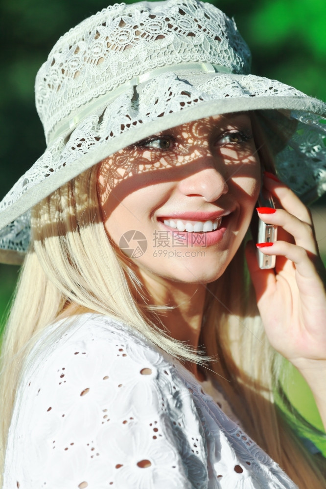 一个美丽的年轻女士手机上的一个电话微笑女商人白色的图片