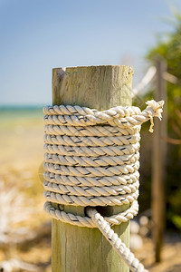 蓝色的白海洋绳系在边木杆上绳索图片