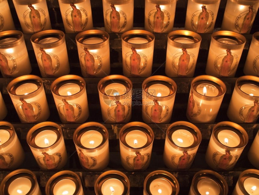 拉根闪烁在巴黎圣母教堂点燃了一串献身祈祷的蜡烛并提供了光辉照耀虔诚的图片