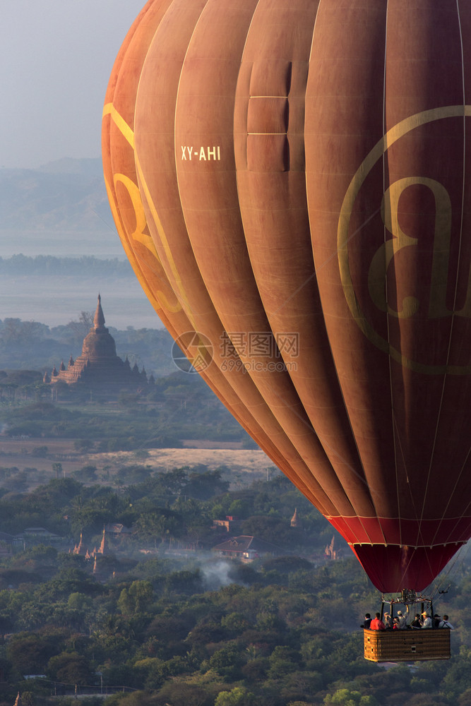 冷静的清晨缅甸阳光下在Bagan的考古区寺庙上空飞行的热气球中观光者们在缅甸热的早期图片