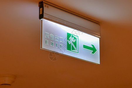 英语在商场的天花板上用中文和英字写出紧急口标志贴近紧急出口标志定向的箭设计图片