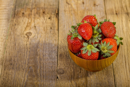 新鲜的老白色旧木制背景碗中新鲜草莓图片
