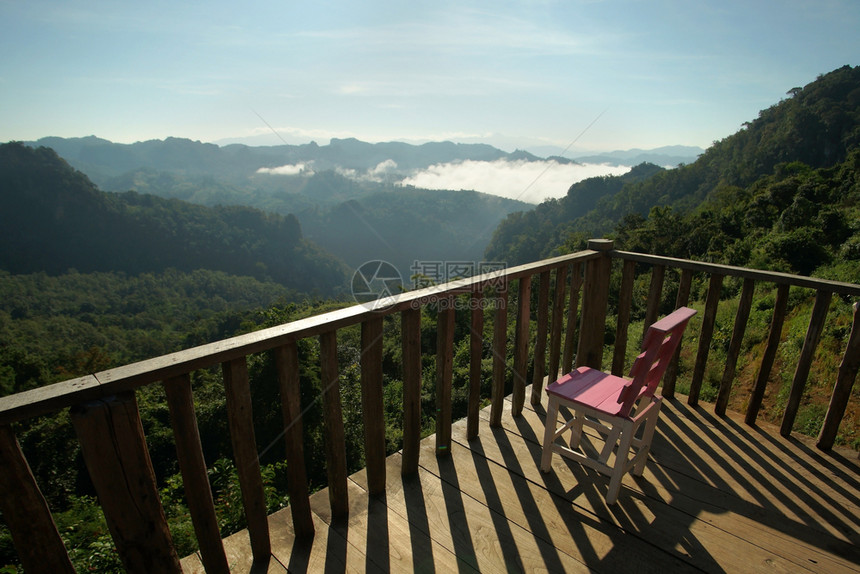 假期爬坡道清晨露天阳台上的粉红木椅子有迷雾山丘背景早晨图片