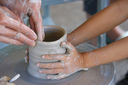 老的一个手和小孩起做花瓶陶器的老人瓷制品一种图片
