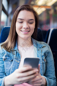 互联网手机在火车旅行期间移动电话上发短信的年轻妇女移动图片