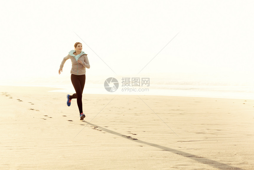 运动女孩速度美丽健康的女人在沙滩上奔跑图片