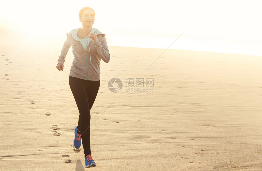 快乐的赛跑者美丽健康的女人在沙滩上奔跑白种人图片