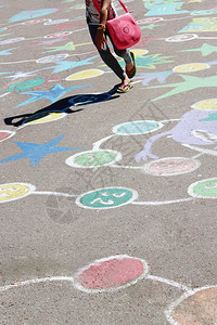 儿童在沥青上跳着幼童的绘画在沥青上跳着幼童的绘画作为游戏绿色户外腿图片