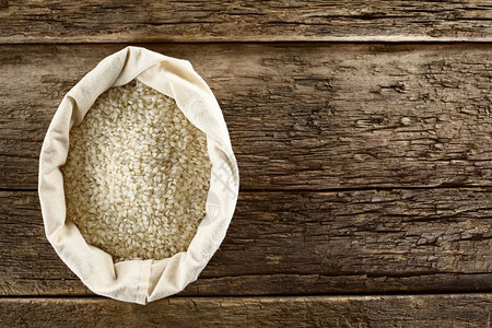 淀粉质的营养乔木重点袋装生的arborio烩饭短粒米在木头上拍摄选择焦点专注于大米RawArborioRisottoRice背景