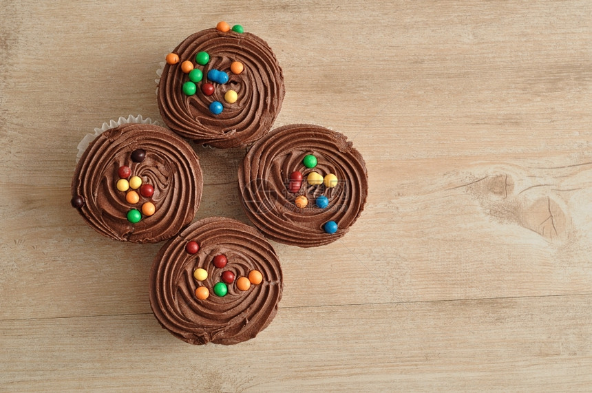 巧克力杯饼霜冻和彩色糖果装饰的巧克力蛋糕黑暗的可口甜图片