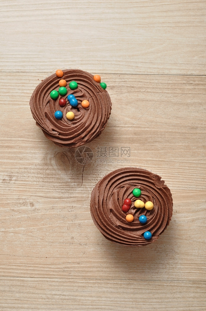 庆典可口自制巧克力杯饼霜冻和彩色糖果装饰的巧克力蛋糕图片