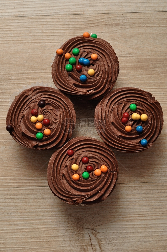 冰镇巧克力杯饼霜冻和彩色糖果装饰的巧克力蛋糕庆典小吃图片