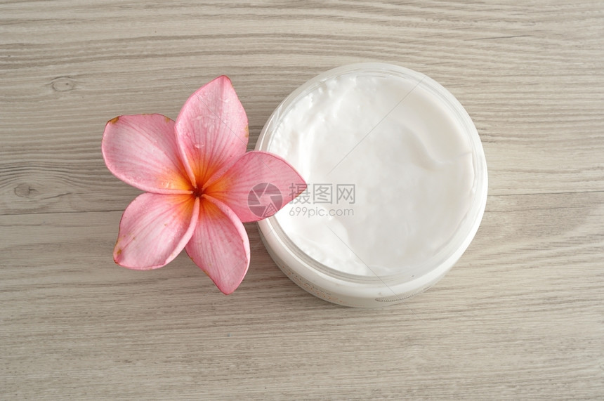 产品老化在装有粉红色freangipani花朵的容器中进行体液浸润皮肤护理图片