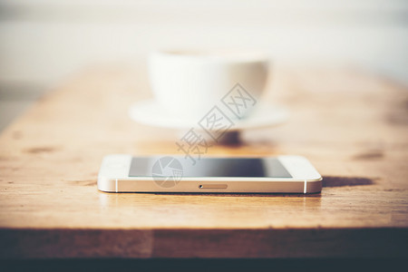 桌上放着的手机和咖啡杯图片