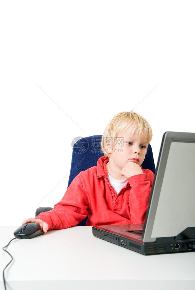 浓度自在年轻的金发男孩在笔记本电脑后面用鼠标复制空间图片